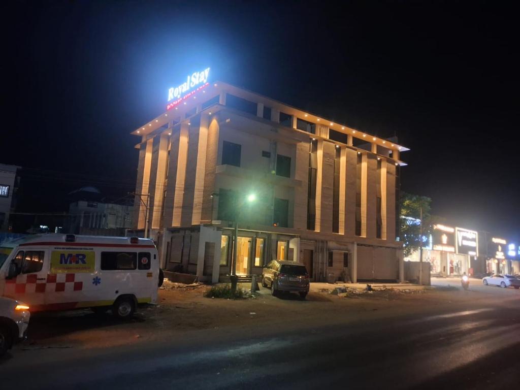 a hotel with a van parked in front of it at night at Hotel Royal Stay in Madurai