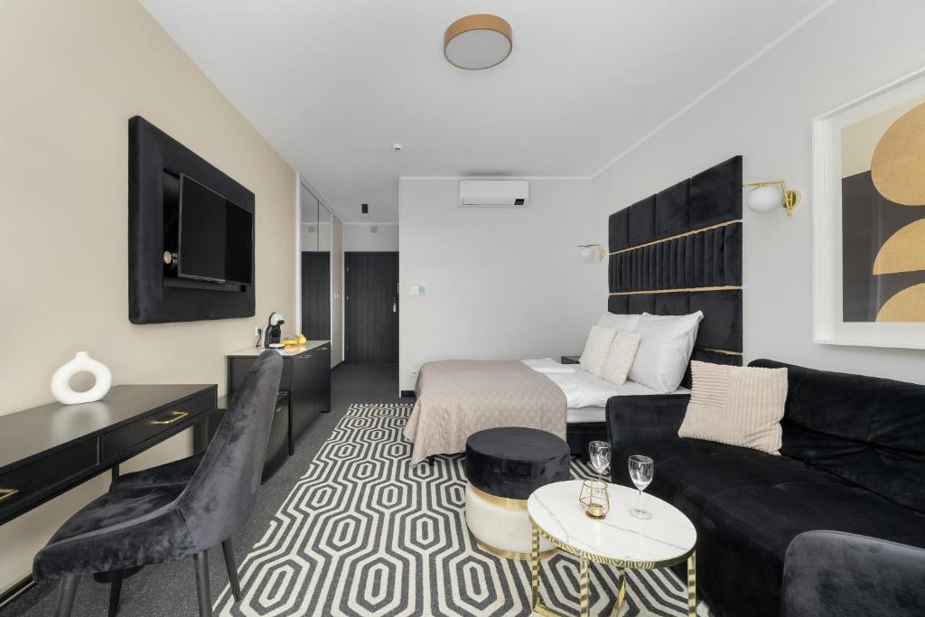a living room with a couch and a bed at Solny Resort Apartament A245 in Kołobrzeg