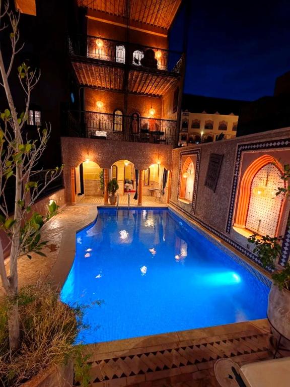 a large swimming pool in a yard at night at Dar Rihana Dadès in Aït Idaïr