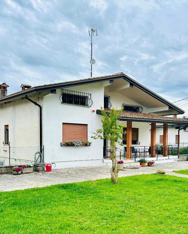 a white house with a tree in front of it at AlMi House - Colline del Prosecco in Soligo
