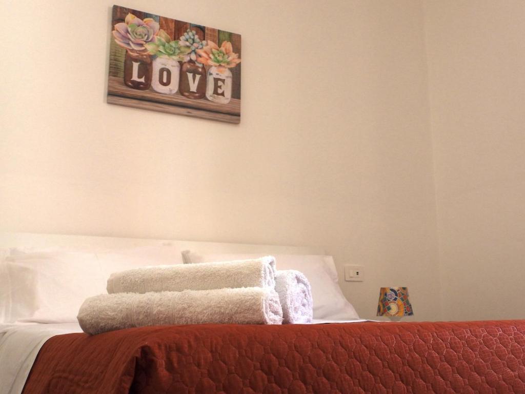 a bedroom with a bed with towels on it at Doribella Holiday House in Pollina