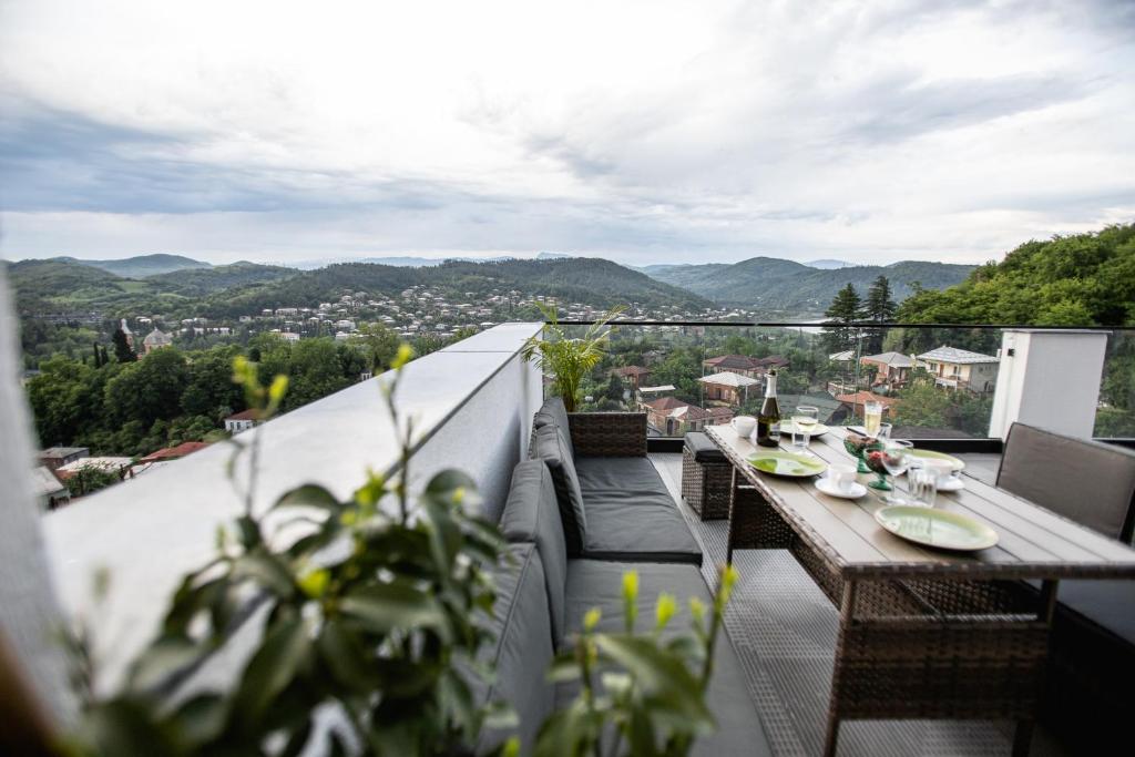 a balcony with a table and chairs and a view at AUTOGRAPH Kutaisi in Kutaisi