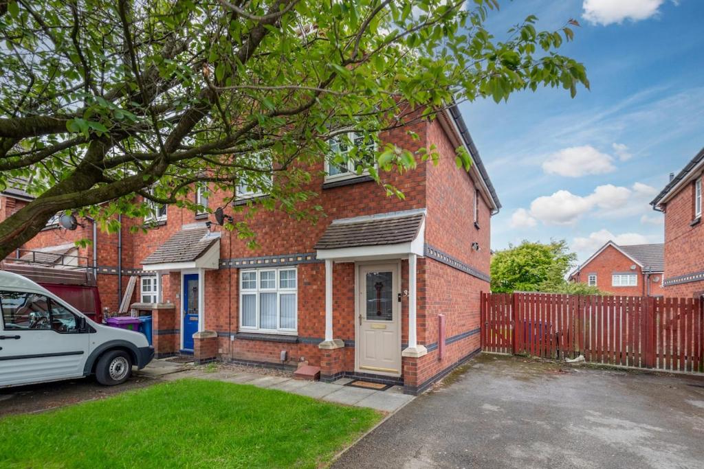 a brick house with a car parked in the driveway at Recently Refurbished House Sleeps 5 near Stadiums in Liverpool