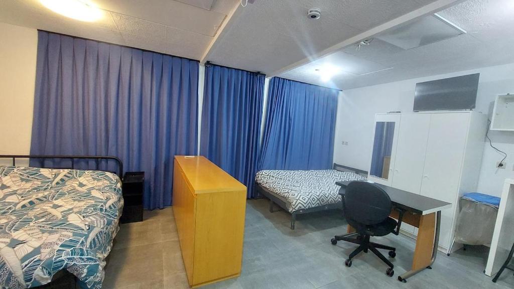 a room with a bed and a desk and a bed and a desk at Cozy studio apartment with 2 beds and kitchen in Audun-le-Tiche