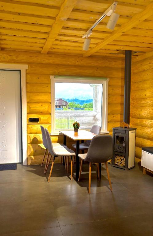a dining room with a table and chairs and a window at Mountain View in Vyshkove
