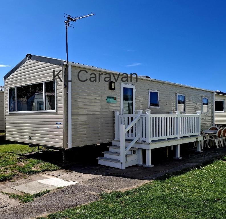 a mobile home with a porch and a deck at KL Caravan in Prestatyn