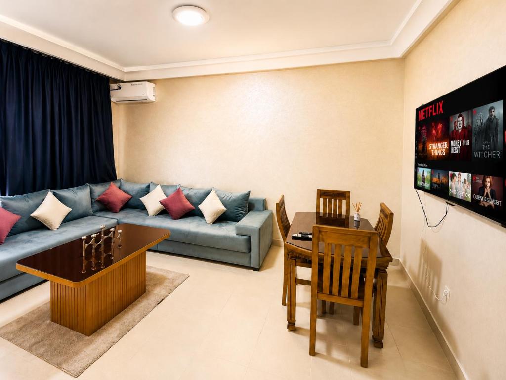 a living room with a couch and a table at Appartement Climatisé 2 Chambres à Marrakech Proche Golf & Jamaâ El Fna in Marrakesh