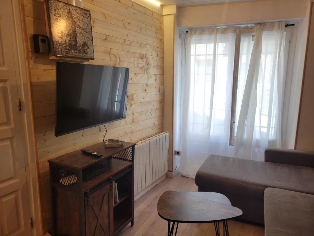 ein Wohnzimmer mit Sofa und Flachbildfernseher in der Unterkunft Rustic ABAT 18 in Puigcerdà