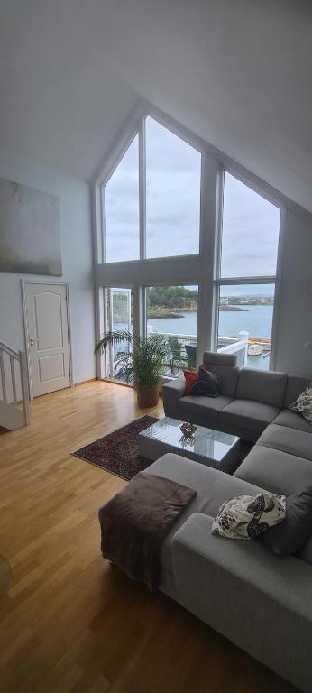 a living room with a couch and a large window at Silent Seaview Luxury Apartment Grasholmen in Stavanger