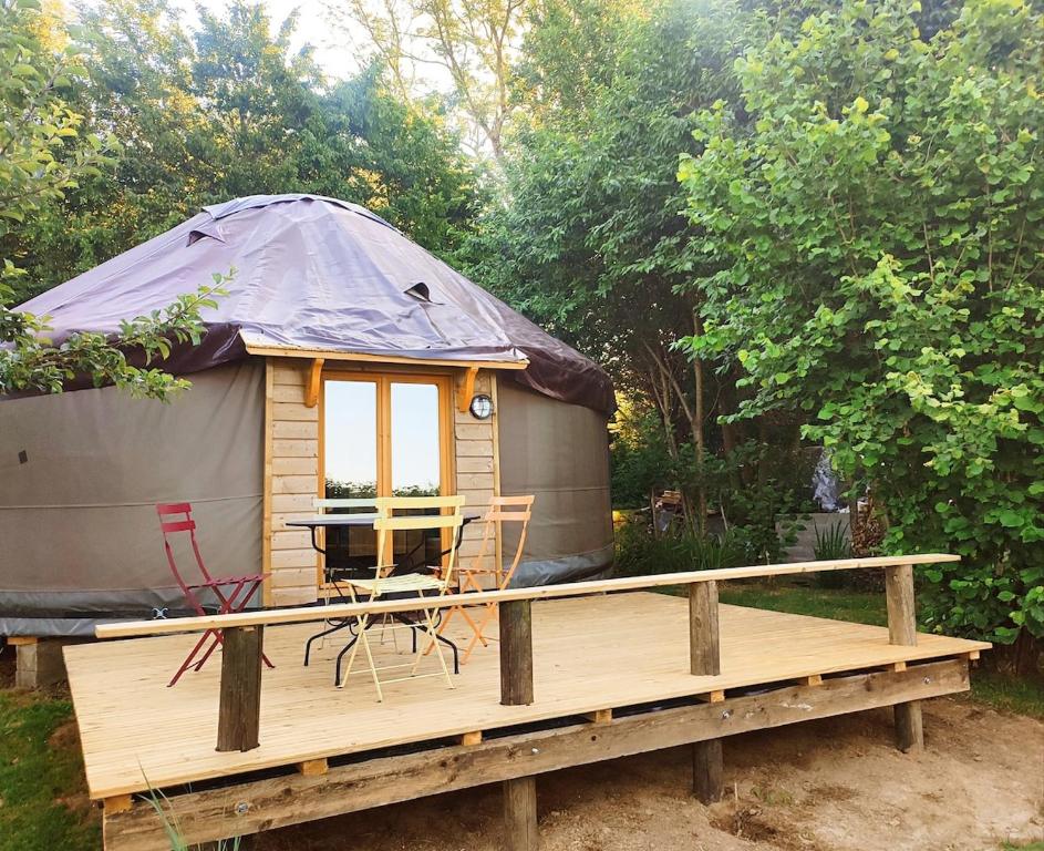 a yurt with a table and chairs on a wooden deck at Au Clères de yourte in Cléres