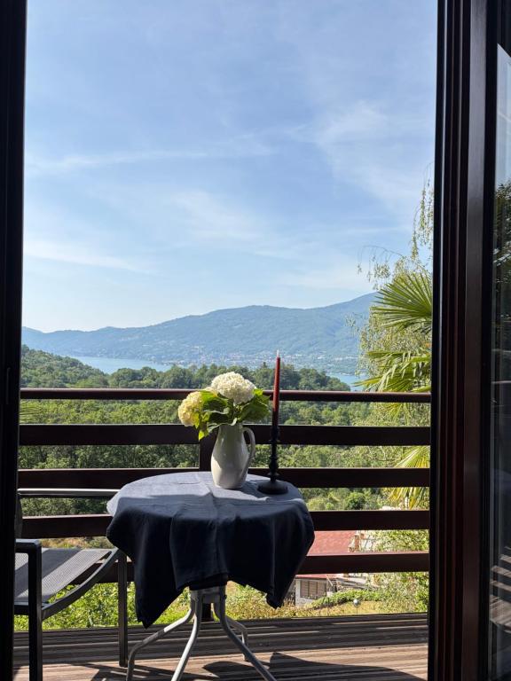 a table with a vase of flowers on a balcony at Rustico Villa Antonia with seaview and pool in Bieno