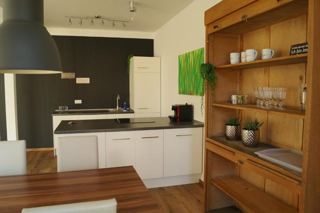 eine Küche mit weißen Schränken und einer schwarzen Arbeitsplatte in der Unterkunft Loft Style 3 Room Apartment + terrace in Villingen-Schwenningen
