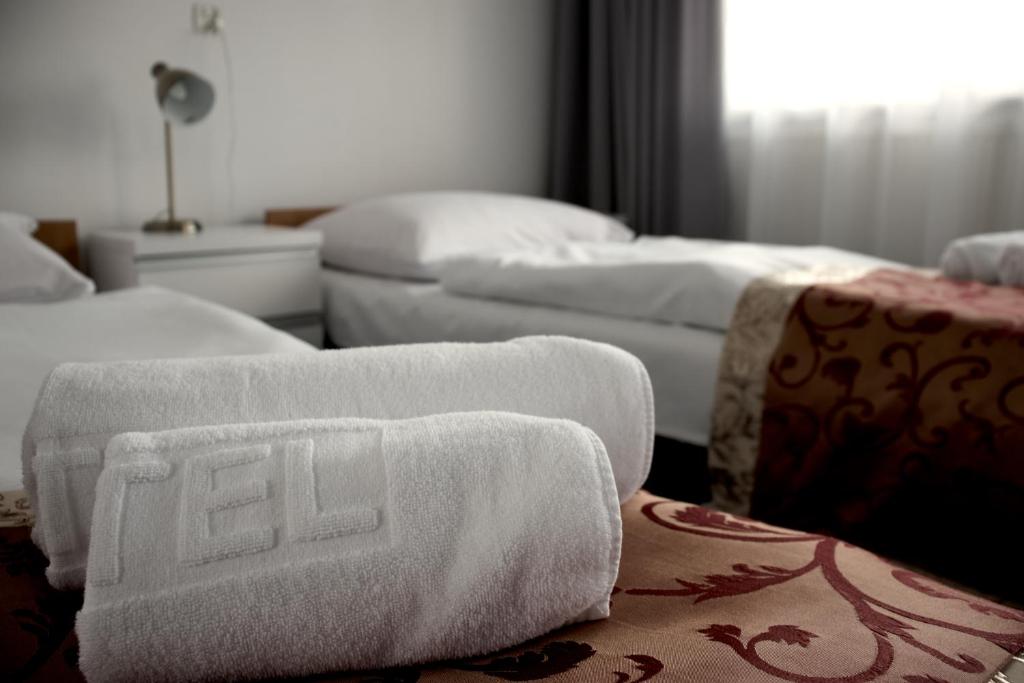 a room with three beds with towels on the floor at Złoty Łan in Nowa Sól