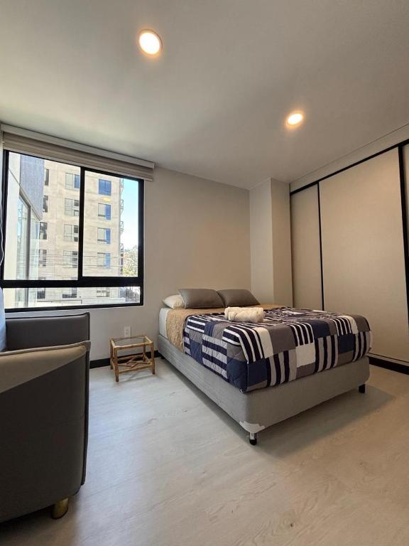 a bedroom with a bed and two large windows at Aura Exclusive - Achumani in La Paz