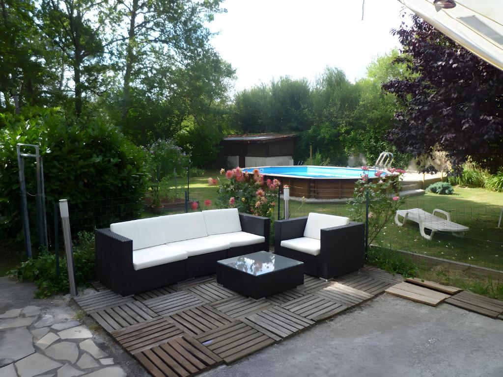 a patio with a couch and a table and a pool at Chambre D'hôtes Indépendante in Pessac