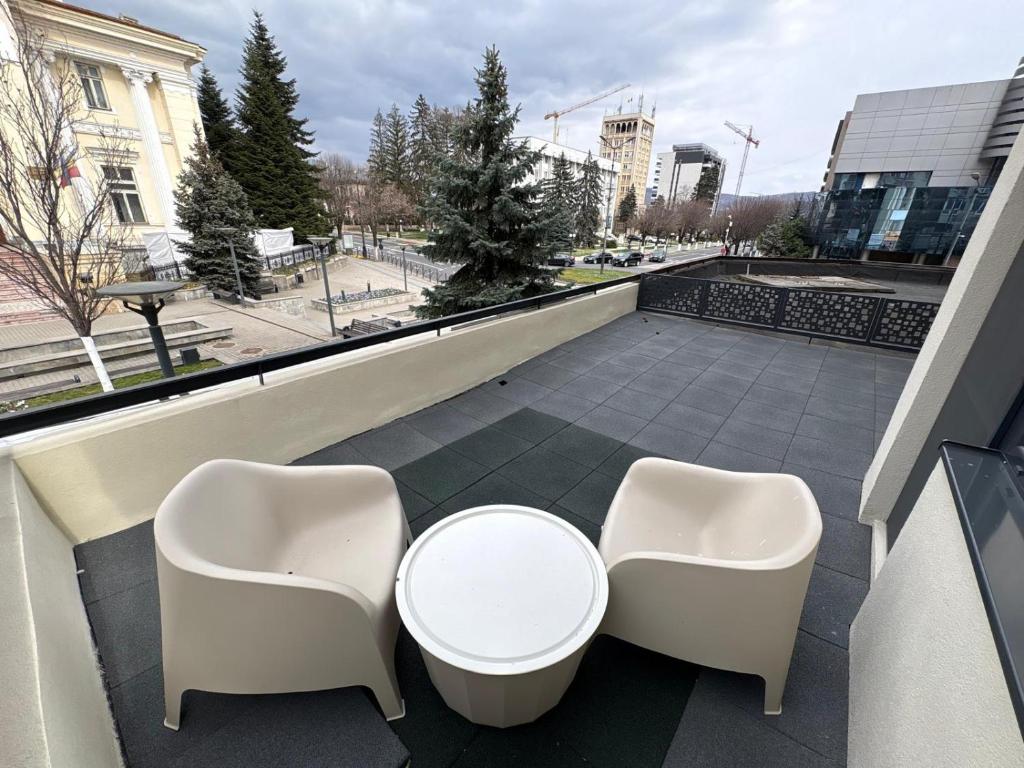 a balcony with two chairs and a table on a building at City View Apartment in Râmnicu Vâlcea