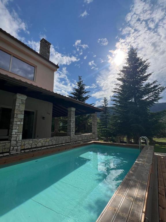 a swimming pool in front of a house at eleni's villa in Kandhíla