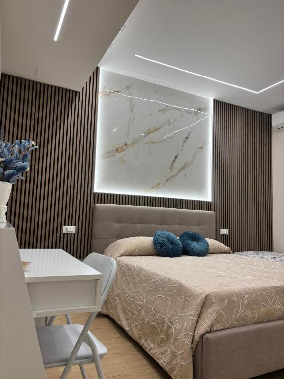 a bedroom with a bed with blue pillows on it at The Superhost - Marekiaro in Crotone