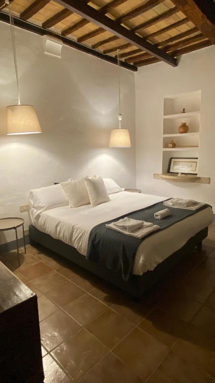 a bedroom with a large bed with two lights at Window to Bagno Vignoni in Bagno Vignoni
