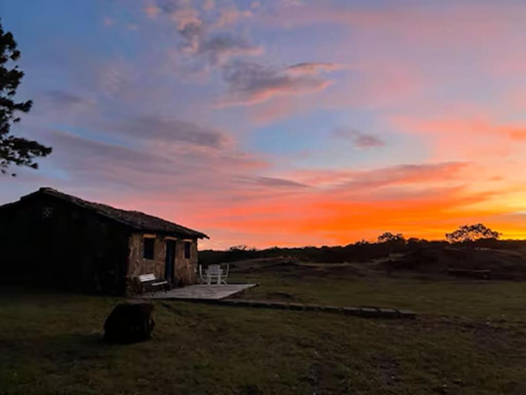 a house in a field with a sunset in the background at Casa Paz by Otium in La Cruz