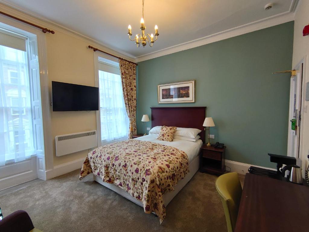 a bedroom with a bed and a chandelier at Sleeping Bear Hotels Dorchester in Dorchester