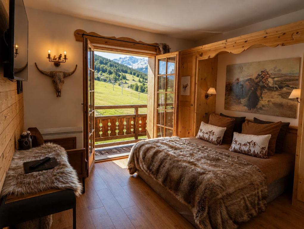 a bedroom with a large bed and a large window at Montana Chalet Hôtel & Spa in Le Sauze