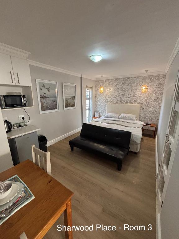 a bedroom with a bed and a table in a room at Sharwood Place in Port Elizabeth