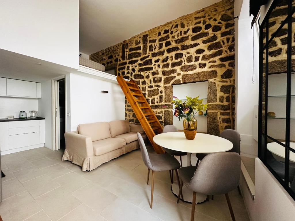 a living room with a table and a stone wall at Victoria in Olbia