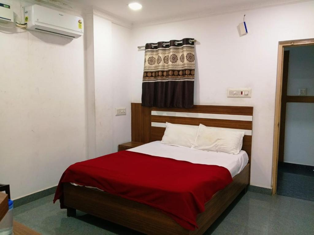 a bedroom with a bed with a red blanket at Pacio Residency in Kanchipuram