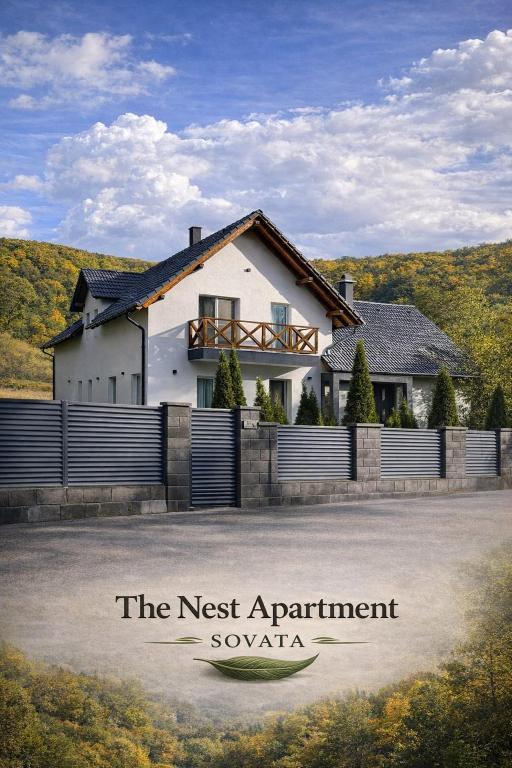 a house with a fence in front of it at The Nest Apartment in Sovata