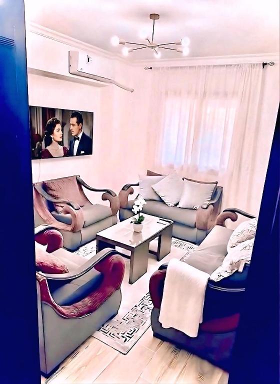 a living room with couches and a table at Modern Flat at Shiekh Zayed in Sheikh Zayed