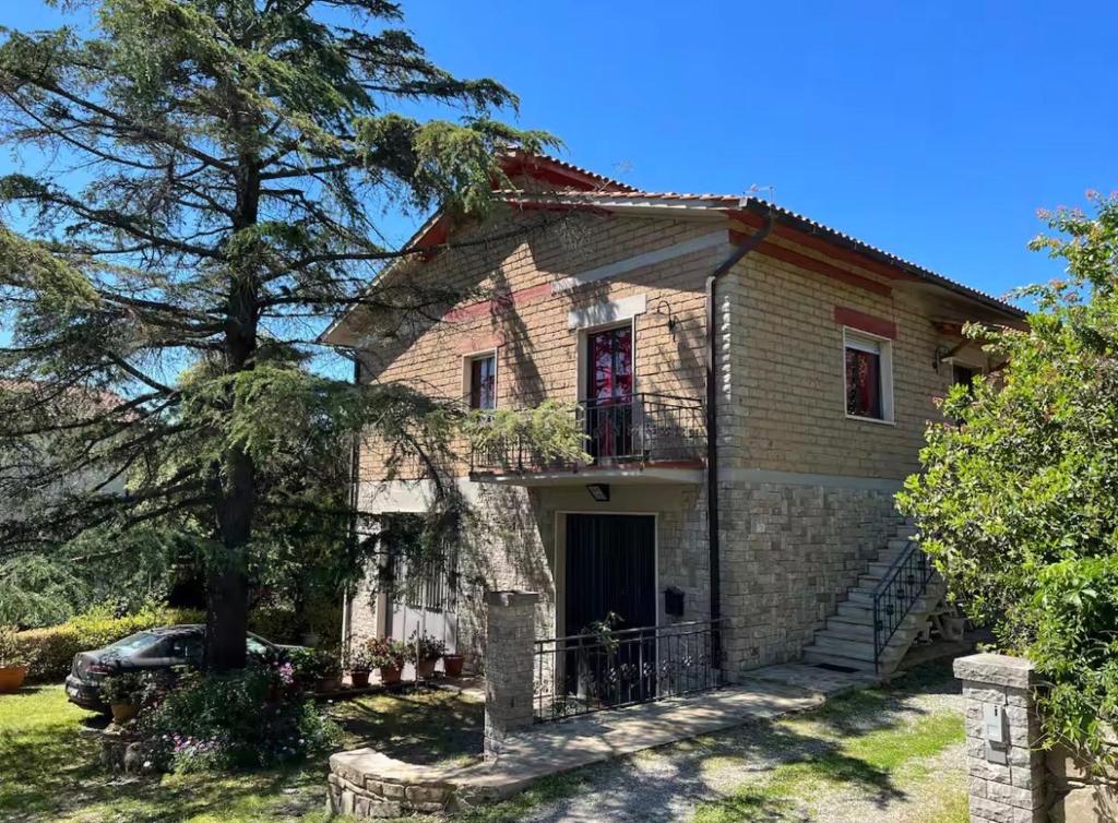 a brick house with a tree in front of it at La Poltrona del Diavolo in Montenero