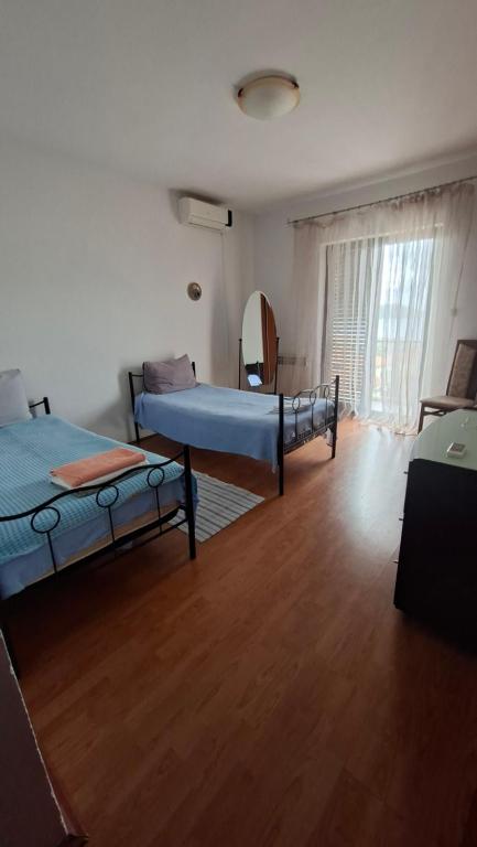 a bedroom with two beds and a wooden floor at Natalia Rooms Old Town in Herceg-Novi