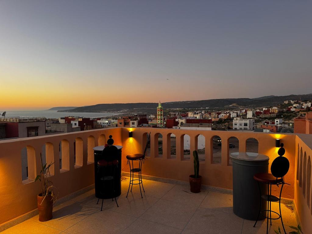 a balcony with a view of a city at sunset at Get Salty Guesthouse in Tamraght Ouzdar