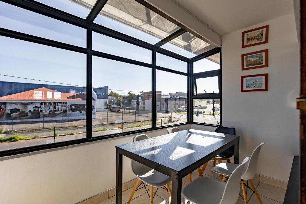 a dining room with a table and chairs and windows at Safi Luxury Self-Catering Suite 8 in East London