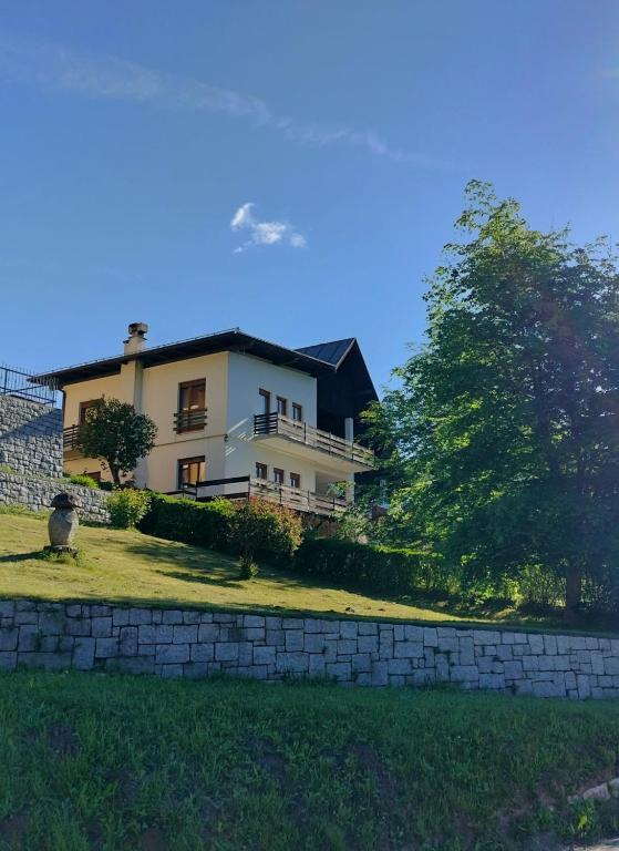 a house on a hill with a stone wall at Casa Silva in Pieve Tesino