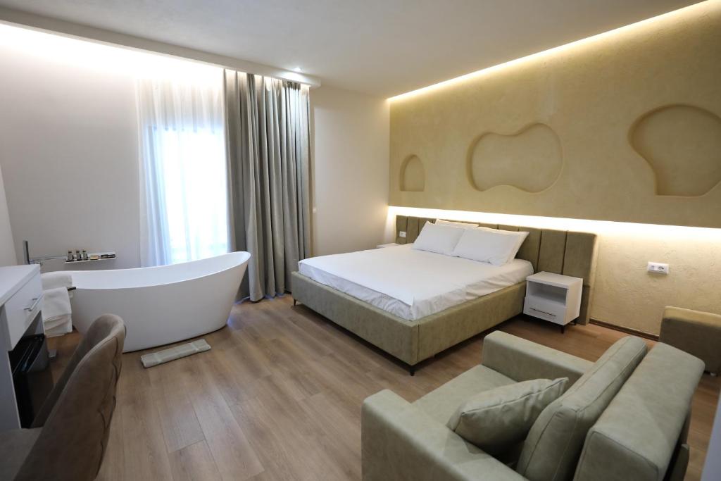 a hotel room with a bed and a bath tub at Andorini Hotel in Finiq