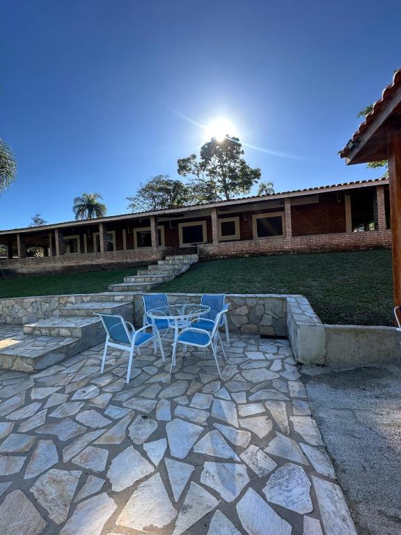 a patio with two chairs and a table and a building at Sítio São Roque in São Roque