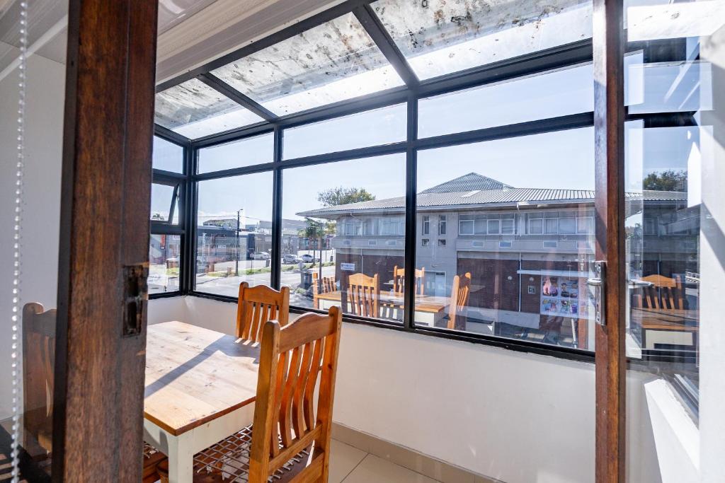 a dining room with large windows and a table and chairs at Safi Elegant Self-catering Suite 5 in East London