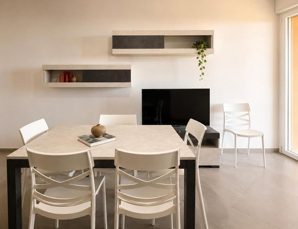 a dining room with a table and white chairs at Casa Mamma Etna in Riposto