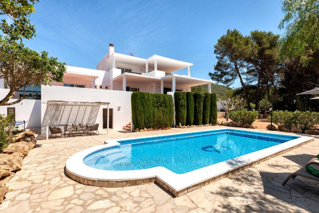 a villa with a swimming pool in front of a house at New! Villa Can Mila in Sant Joan de Labritja
