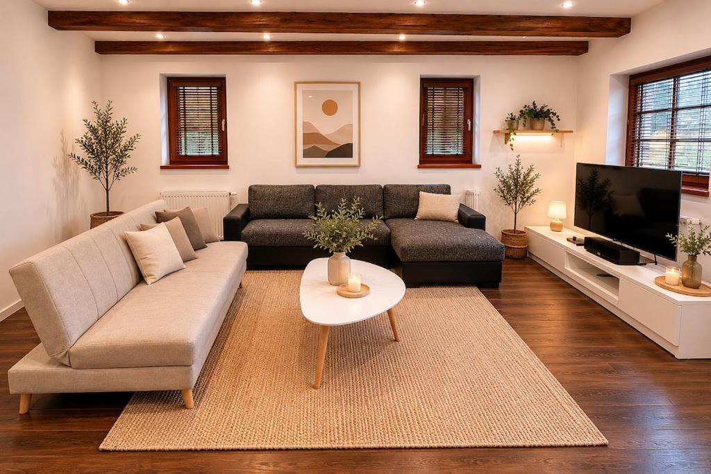 a living room with a couch and a tv at Apartment in Žatec in Žatec