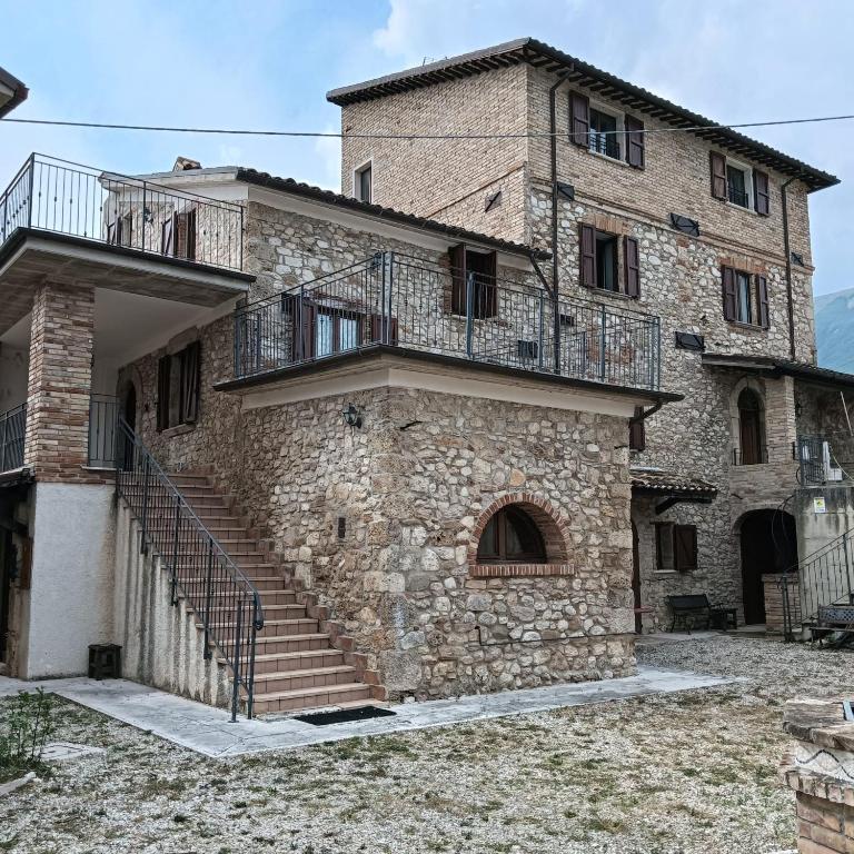 a large stone building with stairs and a balcony at Villa Beregra in Lempa
