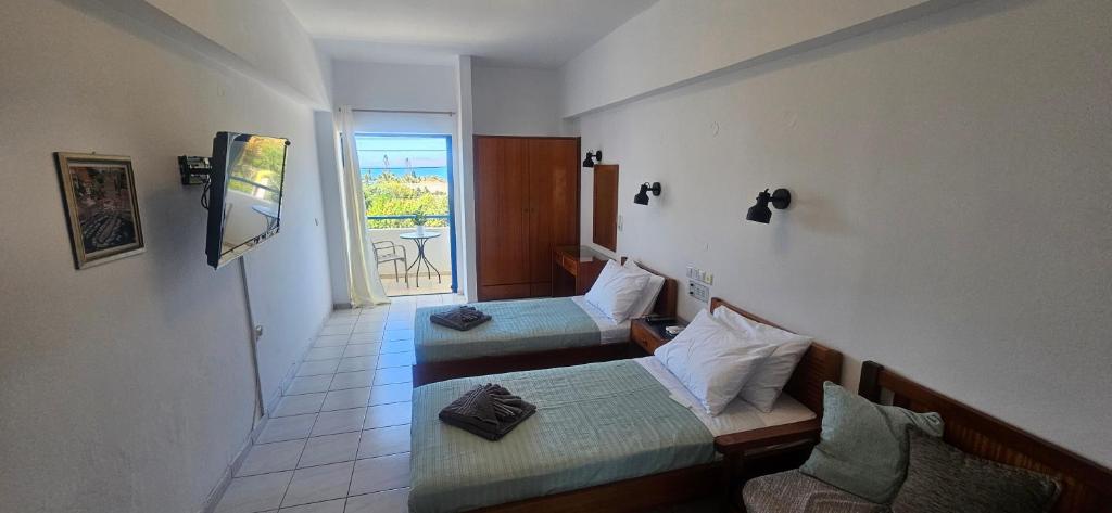 a small room with two beds and a balcony at Sky Eye Studios in Kokkini Khanion