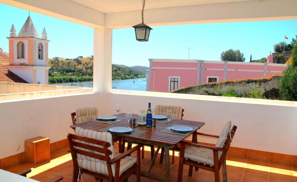 a dining room with a table and chairs on a balcony at Casa C Alcoutim in Alcoutim