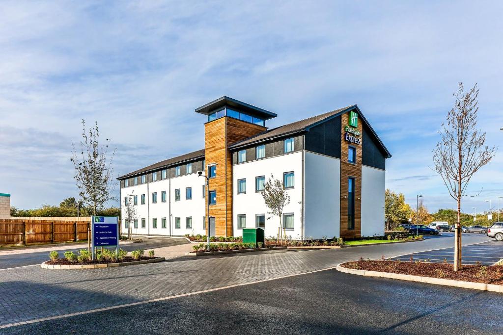 a large white building with a black roof at Holiday Inn Express Cambridge by IHG in Cambridge