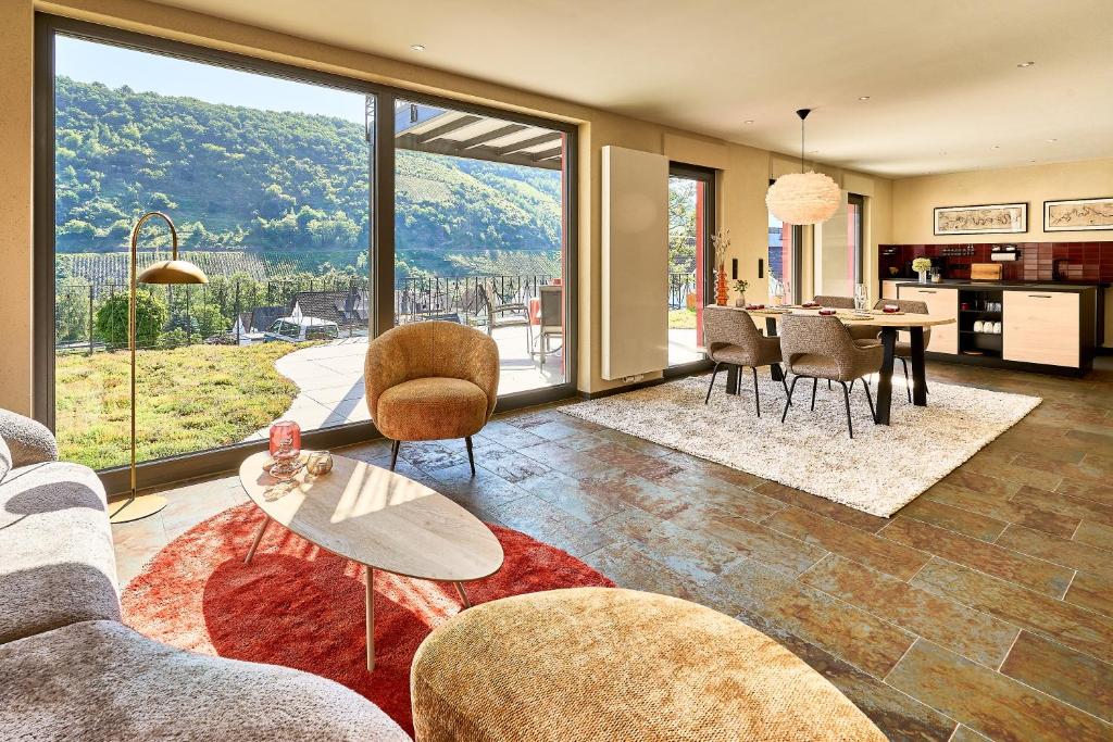 a living room with a table and chairs at Wohnen am Weingut - Über den Fässern in Briedel