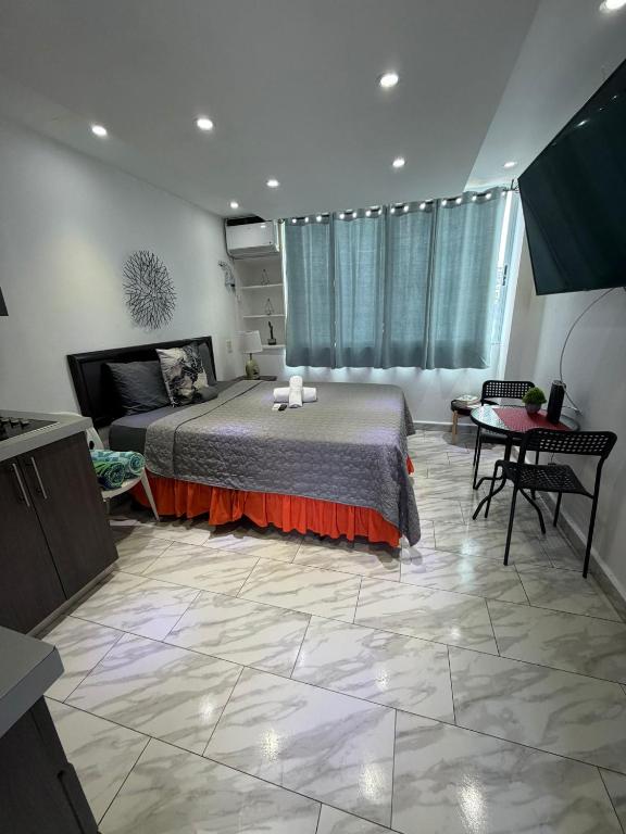 a bedroom with a large bed and a table at Sea breeze vacation lll en Condominio Verde mar in San Juan