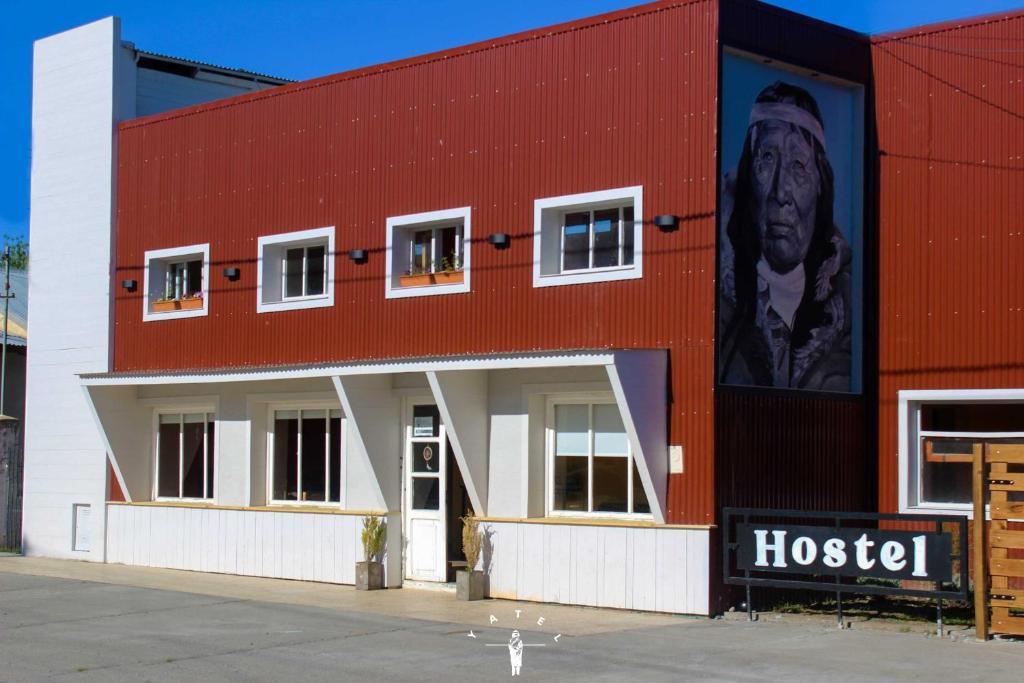 a red building with a large mural on the side of it at Hostel Yatel in El Calafate