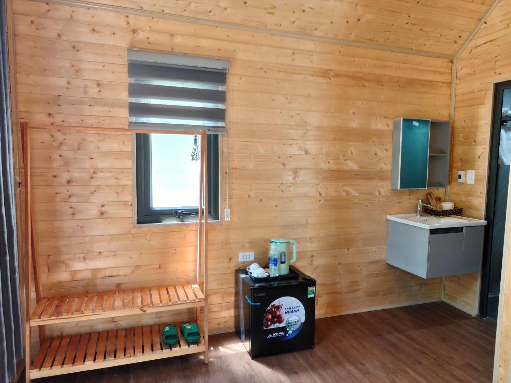 a bathroom with wooden walls and a sink and a window at GiGi's Homestay & Coffee in Phú Xá